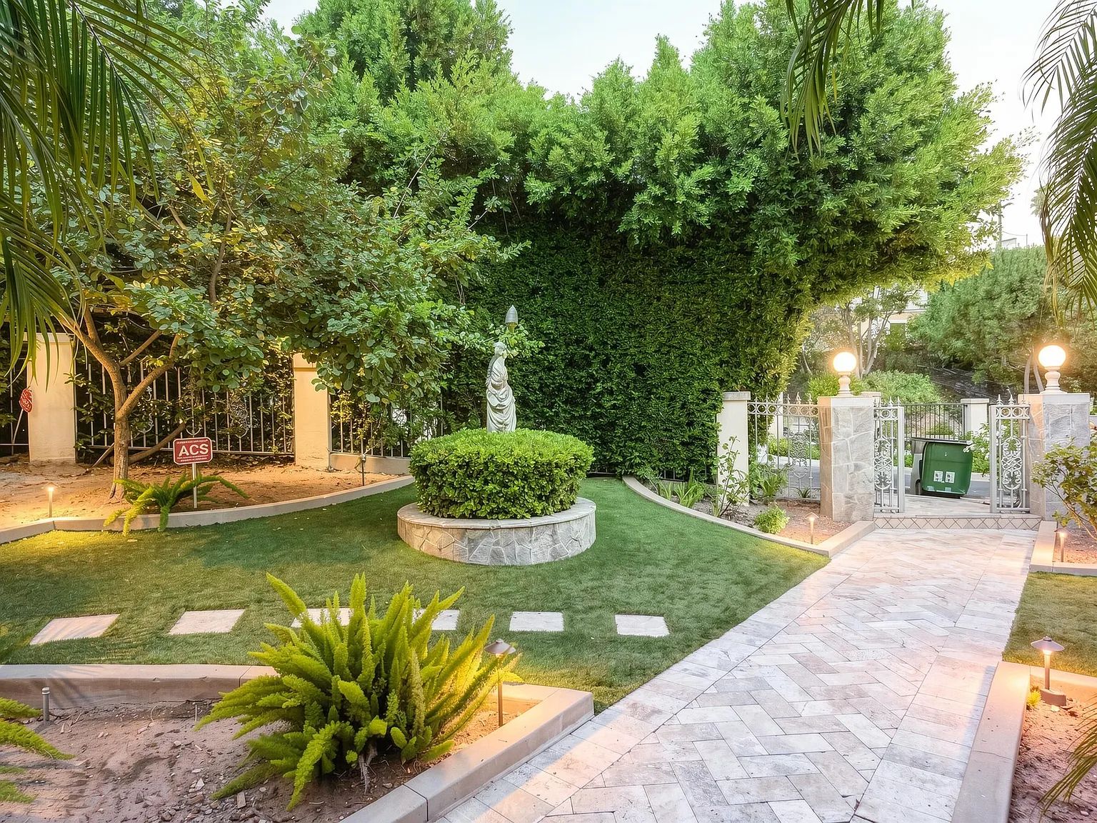 A stone garden path lit at dusk at the Next Phase residence