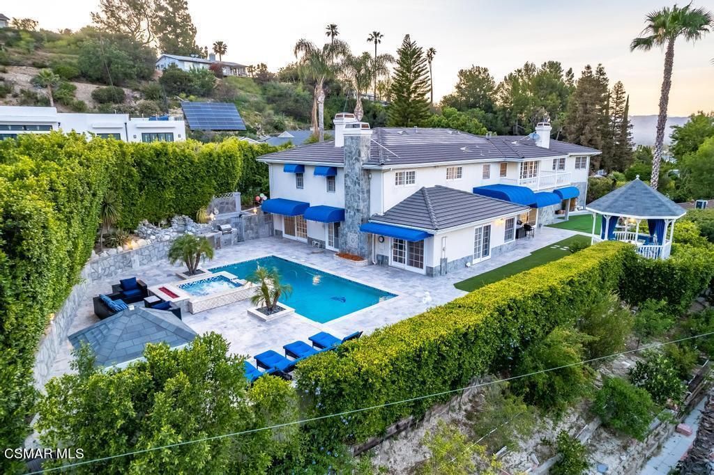 Aerial view of the property, pool, and gardens