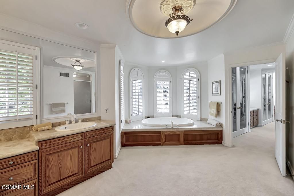 A clean bathroom with soaking tub and arched windows