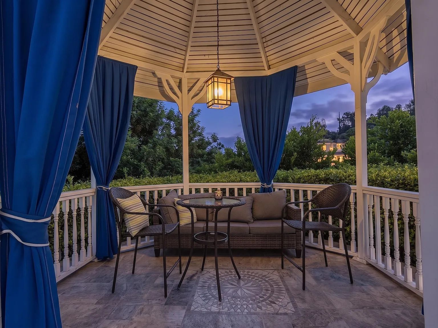 Seating inside the gazebo with blue drapes at dusk